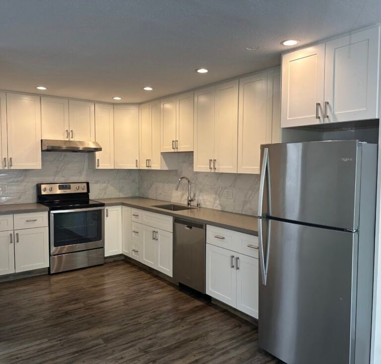 Bright and functional kitchen with white cabinets, stainless steel appliances, and contemporary design for home improvement.